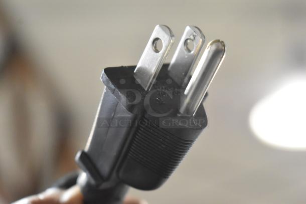 Black electrical plug with three prongs, suitable for 120 Volt appliances, close-up view.