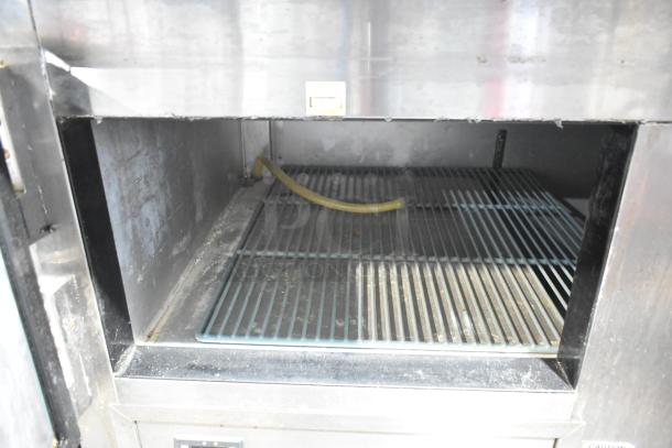 2021 Leader ESPT48 stainless steel pizza prep table interior; features wire shelving and a power cord.