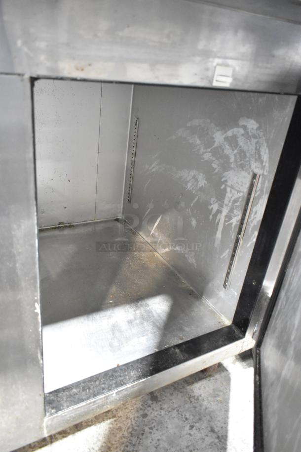 2021 Leader ESPT48 stainless steel commercial pizza prep table interior, showing storage space, commercial casters visible.