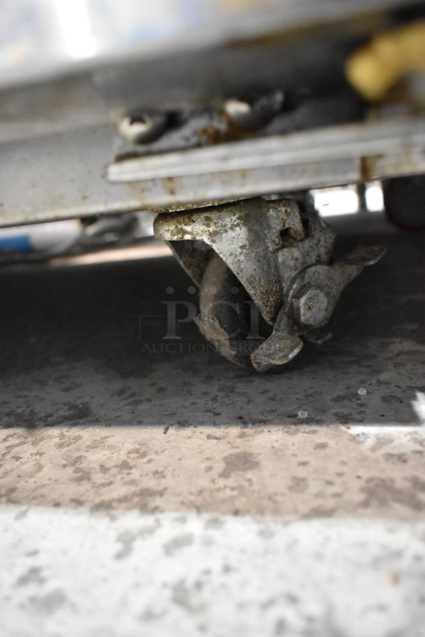 Rusted caster wheel of a 2016 Continental SW48-18M stainless steel sandwich salad prep table, indicating wear.