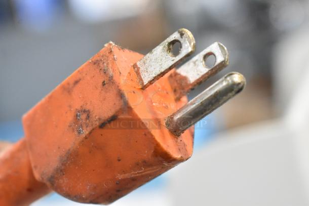 Close-up of a worn, orange power plug with visible grime, suitable for the 5MCR501 Metal Commercial Countertop Dough Sheeter.