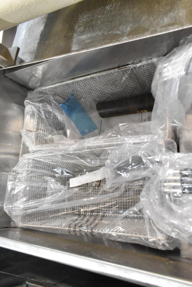 KUT50FRN50SNG stainless steel commercial deep fat fryer with two metal fry baskets, shown in protective wrapping.