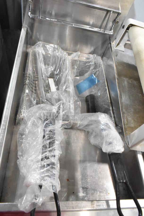 KUT50FRN50SNG stainless steel commercial natural gas deep fat fryer with two metal fry baskets in plastic wrap.