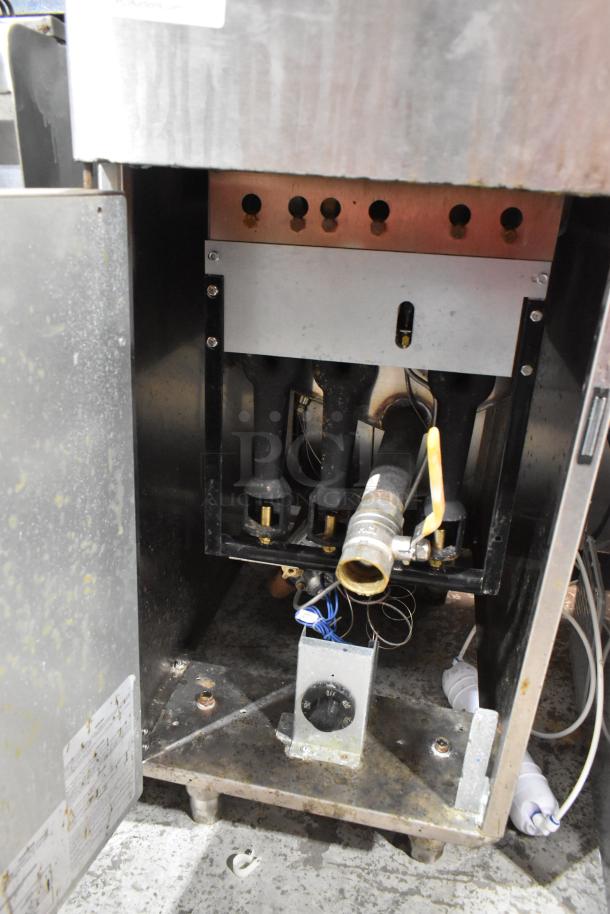 Stainless steel commercial fryer, model KUT50FRN50SNG, with natural gas hookup and wiring visible. Condition shows use.