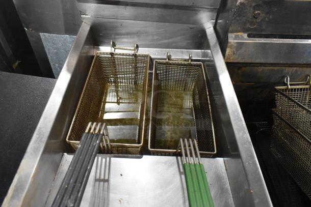 Royal stainless steel commercial deep fat fryer with 2 metal fry baskets, on commercial casters, shown in used condition.
