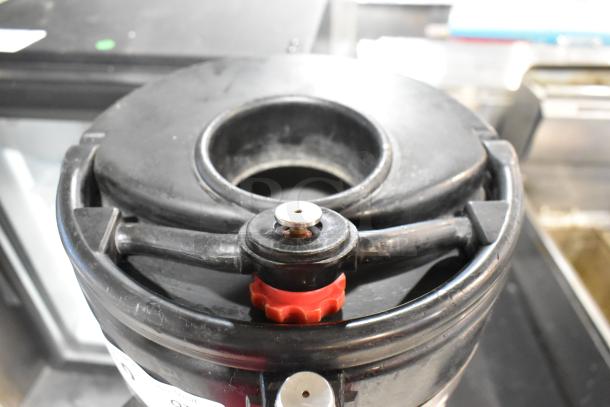 Fetco Luxus Stainless Steel Beverage Dispenser, durable design, visible spout, black and red elements, used condition.