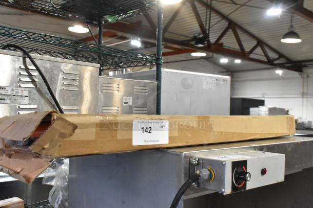 Brand new metal orange piece in original packaging, labeled "142 QTY" on a cardboard box. Box has visible dents.