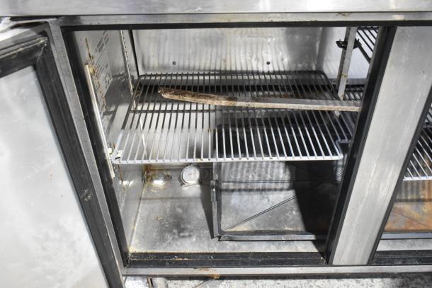True TUC-48 stainless steel undercounter cooler with two doors, commercial casters, 115V, 1 phase. Visible gauges. Used condition.