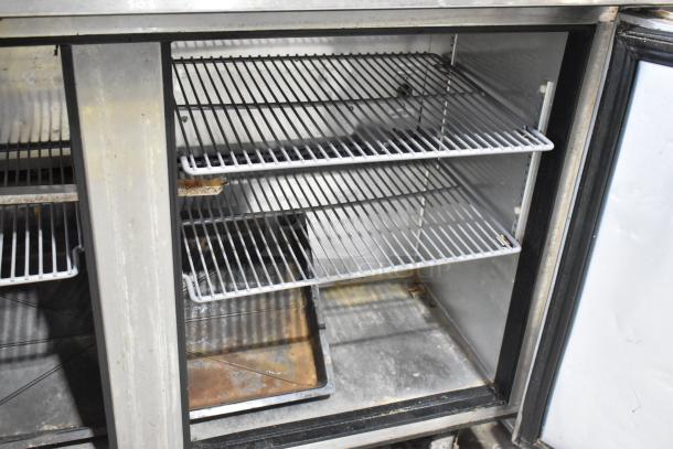 True TUC-48 commercial undercounter cooler, stainless steel, two doors open, showing shelves. Good condition, on casters.