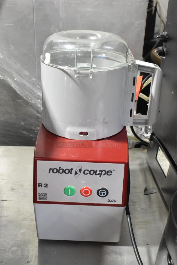 Robot Coupe R2N commercial food processor with bowl, lid, continuous feed head, grater, slicer blades; 120V, 1 phase.