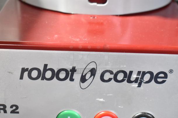 Robot Coupe R2N food processor, red/metal finish, includes bowl, lid, grater, and slicer blades. 120V, 1 phase.
