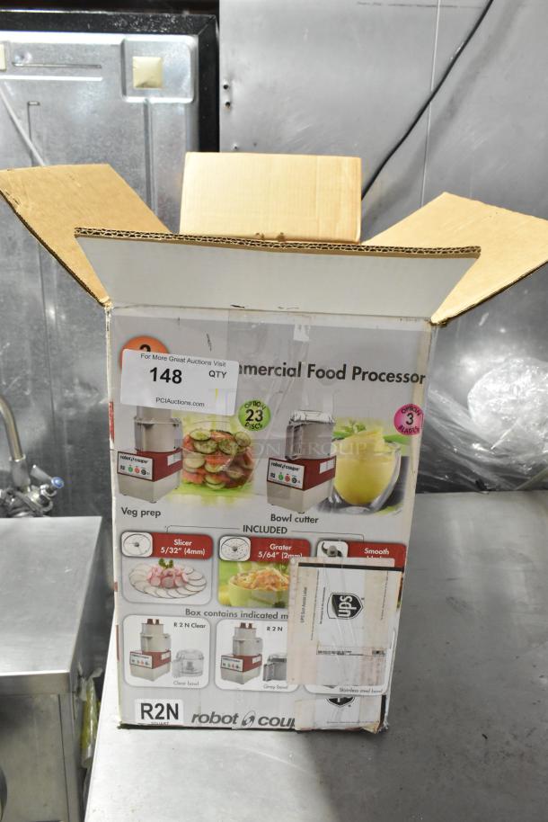 Robot Coupe R2N food processor box, includes bowl, lid, feed head, grater and slicing blades. 120 volts, 1 phase.