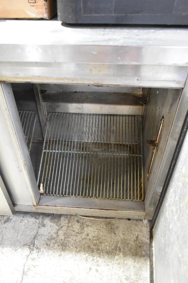 Leader NSFB 48 S/C stainless steel 2-door undercounter cooler with commercial casters. Used condition. 115 Volts, 1 Phase.