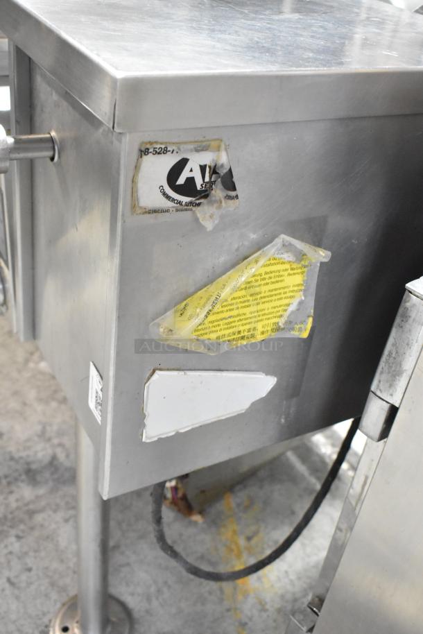 Cleveland stainless steel commercial tilting kettle, floor style, visible wear, labels with usage instructions.