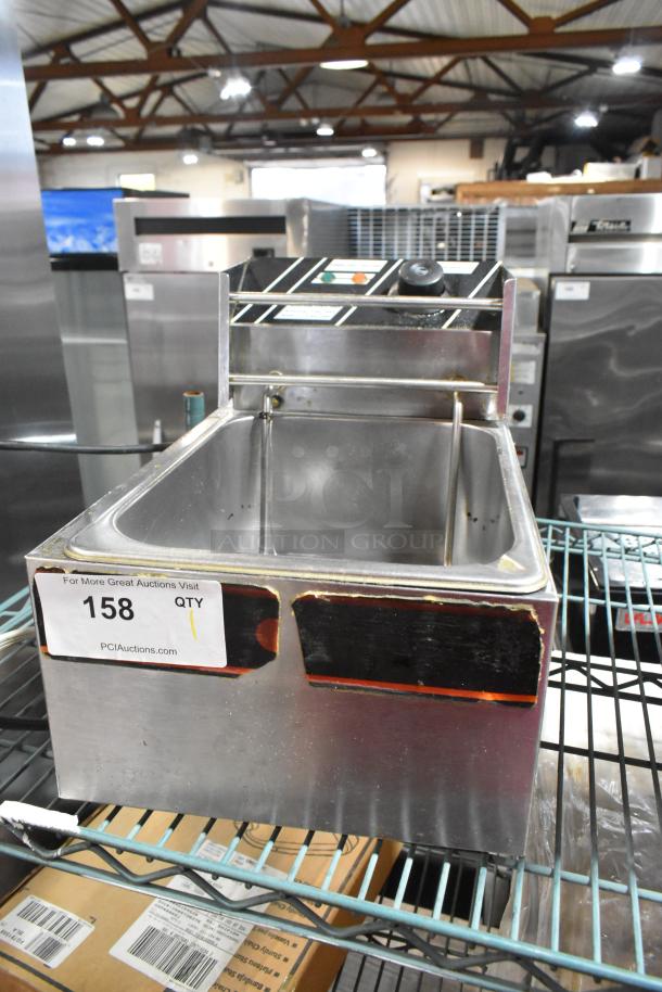Stainless steel countertop electric deep fat fryer, 115 volts, 1 phase. Features control panel and visible wear on surface.