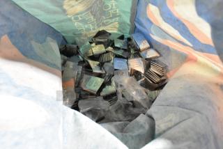 Lot of metal number signs and standing clipboard menu holders in a colorful bag. Various numbers visible on signs.