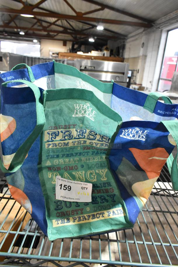 Lot of various items including metal number signs and standing clipboard menu holders in a Whole Foods grocery bag. Condition appears used. Auction tag number 159 attached.