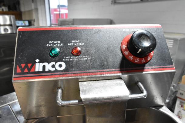 Winco stainless steel electric deep fat fryer with metal fry basket, 115 volts, countertop model, single burner, temperature control knob.
