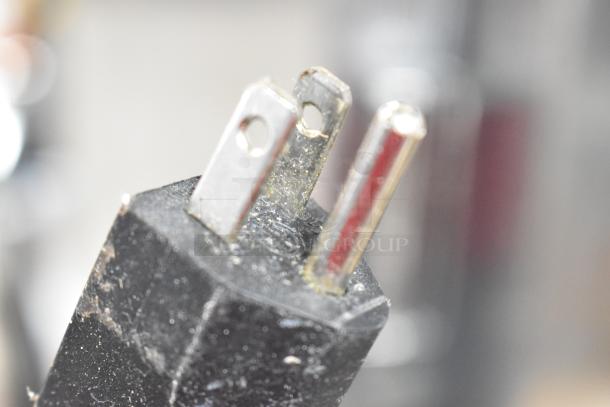 Close-up of a three-prong plug for a Winco Electric Deep Fat Fryer, 115 volts, showing slight wear.