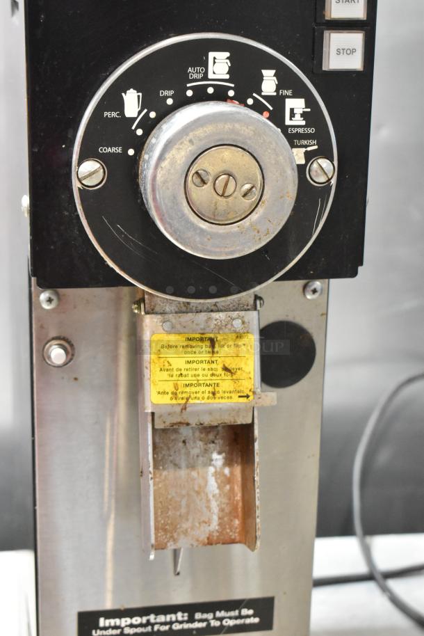 Grindmaster 890-B-T metal commercial coffee grinder, various grind settings, visible wear. Important usage instructions on label.