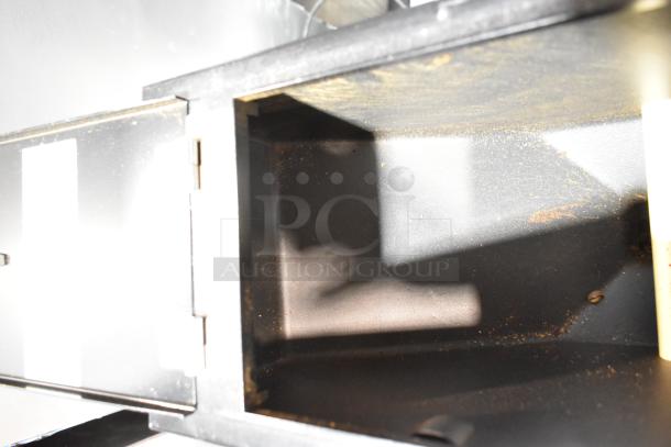 Grindmaster 890-B-T commercial coffee grinder, metal body, 115 volts, 1 phase, interior view with coffee residue.