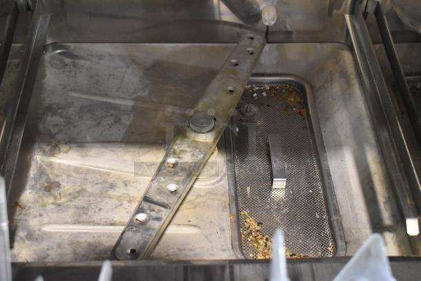 2016 Champion UH130B stainless steel commercial undercounter dishwasher, interior view, showing wear and debris. Model UH130B, 120-208/230V.