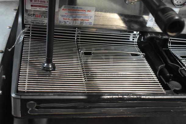 Schaerer Barista stainless steel 2 group espresso machine with portafilter, steam wand, and service labels visible.