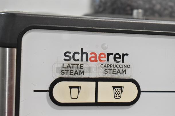 Schaerer Barista espresso machine detail, shows latte and cappuccino steam buttons, stainless steel housing. Model Barista.