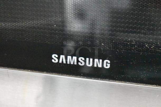 Samsung MG11H2020CT countertop microwave, 120V, 1 Phase. Black and silver finish, includes plate. Visible Samsung logo.
