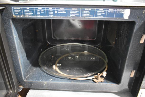 Samsung MG11H2020CT countertop microwave oven with glass plate, visible interior labels, used condition, 120 volts.