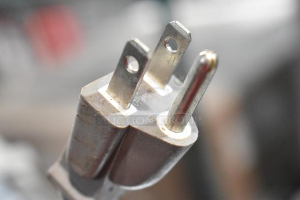 Close-up view of a standard three-prong plug, possibly for Samsung MG11H2020CT microwave.