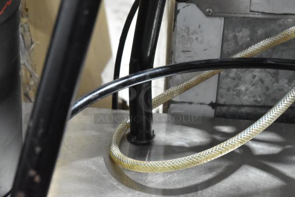 A close-up of black metal legs and a part of a wooden stool, showing industrial design elements.