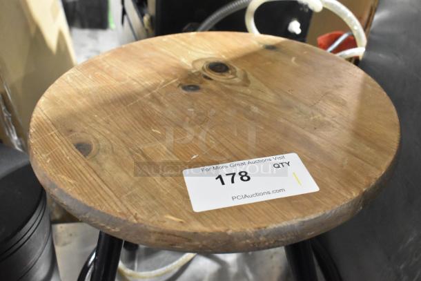 Wooden and black metal stool with round wooden seat and metal legs. Visible auction tag reads "178", indicating auction item.