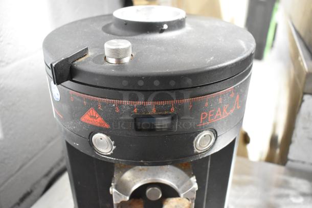 Mahlkonig Peak espresso grinder base, metal, commercial use, no hopper, 120V, 1 phase. Visible markings and controls.