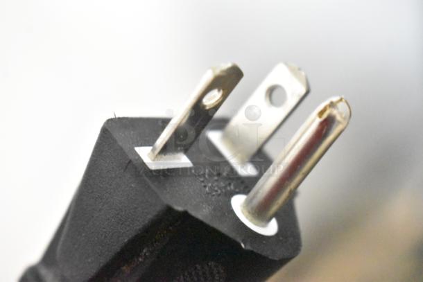 Close-up of a three-prong power plug for the Avantco 177DPO18DD pizza/bakery oven, showing metal prongs and black casing.