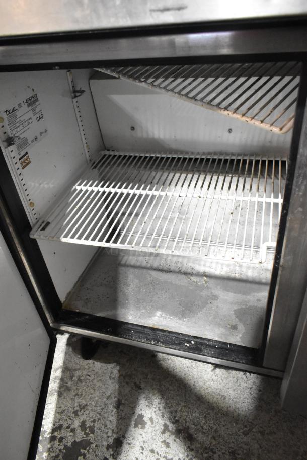 True TUC-48F stainless steel commercial undercounter freezer, two doors, commercial casters, visible interior shelves.