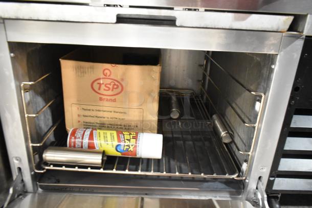 Cooking Performance Group 351S24N stainless steel commercial range oven, natural gas, 4 burners, interior view with stored items.