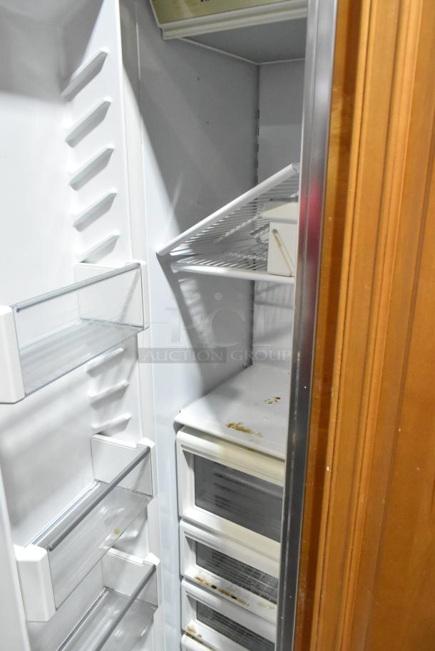 Sub-Zero wood panel 2 door reach-in cooler with freezer, 115V, 1 phase, adjustable shelves, interior wear visible.