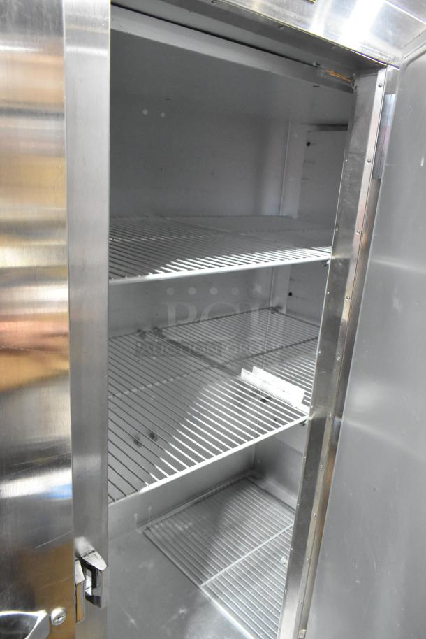 2018 Traulsen G31010 stainless steel commercial 3 door reach-in cooler with poly-coated racks, 115V, 1 phase, clean interior.