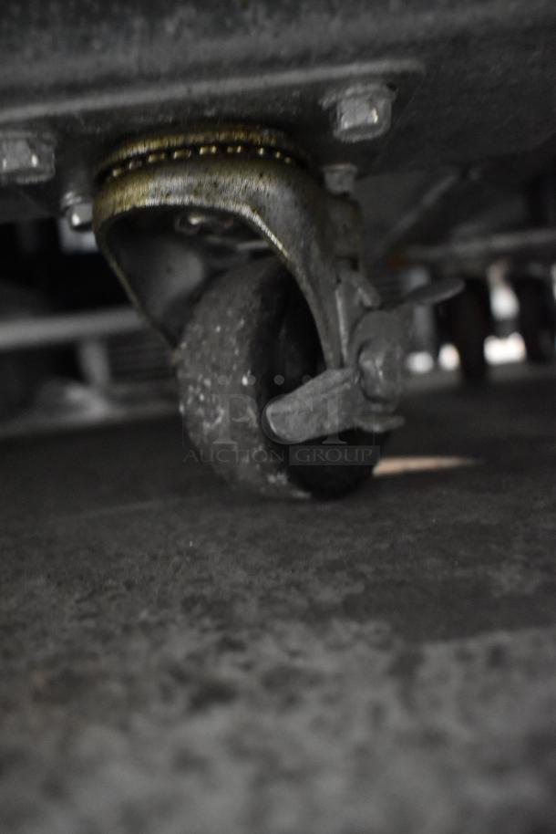 Coldline CFD-2RR-E-HC commercial cooler on casters, poly-coated racks, stainless steel, 115V, 1-phase. Detailed caster view.