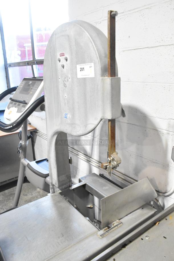 Commercial metal floor-style meat saw in used condition. Features adjustable blade, metallic finish, and visible lot label 201.