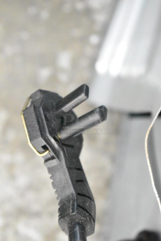 Close-up of a black electrical plug for Manitowoc UDP-0065A commercial ice machine. Scratches visible on plug surface.