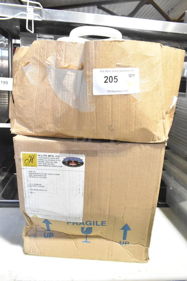 Two sealed boxes from Hi-Lite Mfg. Co. labeled fragile; condition noted as scratch and dent. Includes orange fixture and hose.