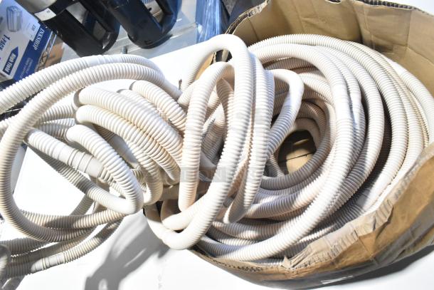 Coiled white hose in cardboard box, labeled "scratch and dent." Includes orange fixture, brand new condition.