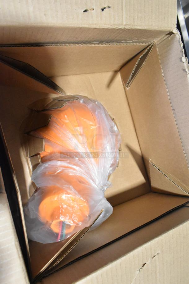 Brand new scratch and dent orange fixture and hose wrapped in plastic, inside an open cardboard box.