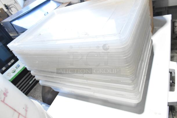 Stack of clear poly bins and lids, slightly used, ideal for storage and organization. Multiple sizes visible.