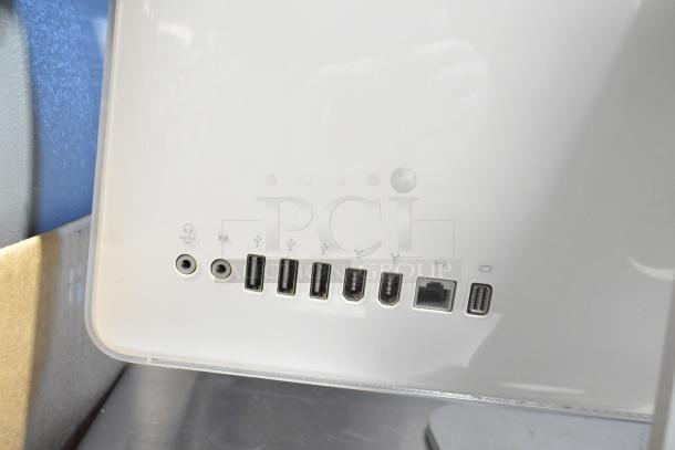 Apple iMac all-in-one computer back view showing multiple ports: audio, USB, FireWire, Ethernet, and Mini DisplayPort.