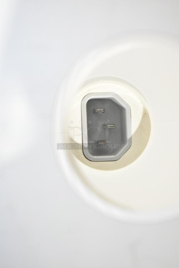 Power port of an Apple iMac computer, showing a three-prong connection, indicative of electrical input.