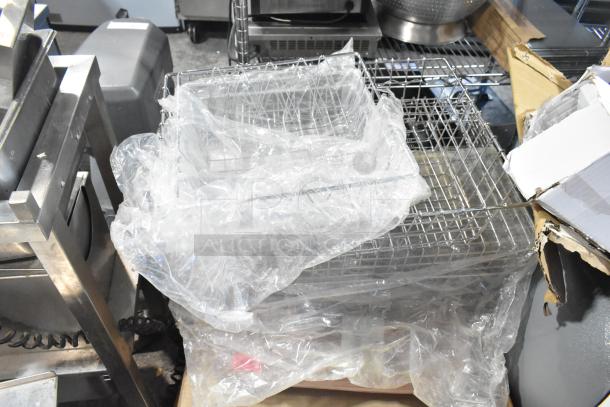 Pallet lot with various items including exit signs, metal baskets, and grease filters, wrapped in plastic.