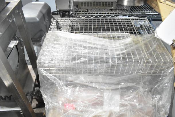 Pallet lot with metal baskets, grease filters, exit signs, butcher paper roll, Fisher faucet handles, wrapped and ready.